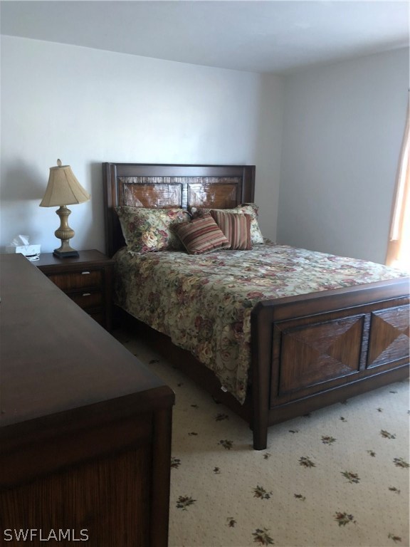 358 Delaware Road Lehigh Acres, FL 33936 - Photo 14 of 22 a bed sitting in a bedroom next to a window