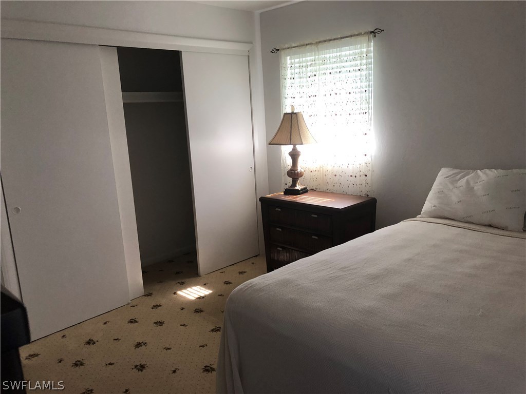 358 Delaware Road Lehigh Acres, FL 33936 - Photo 10 of 22 a bedroom with a bed and a window