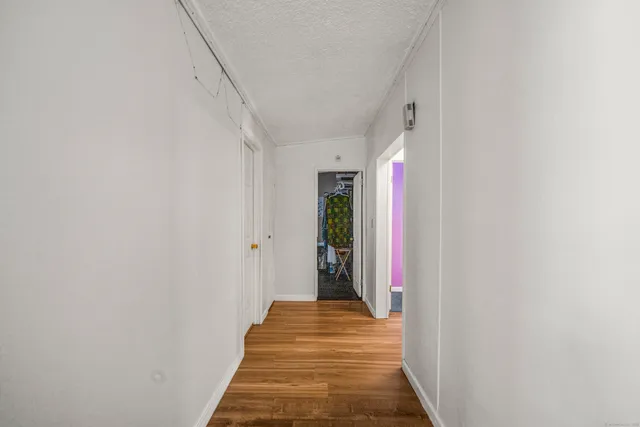 a view of a hallway with wooden floor and entryway