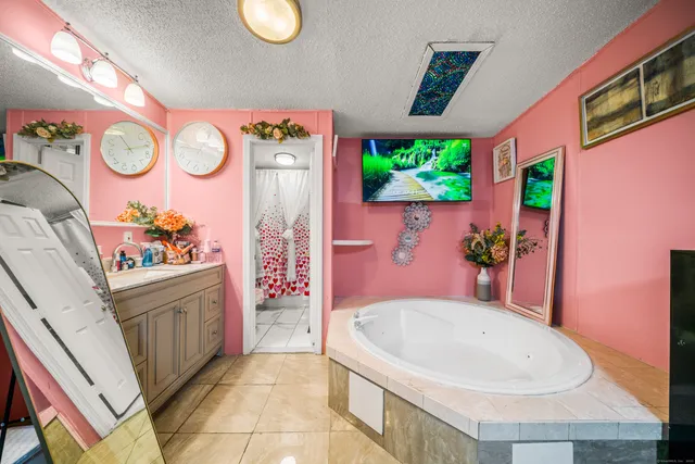 a bathroom with a tub sink and mirror