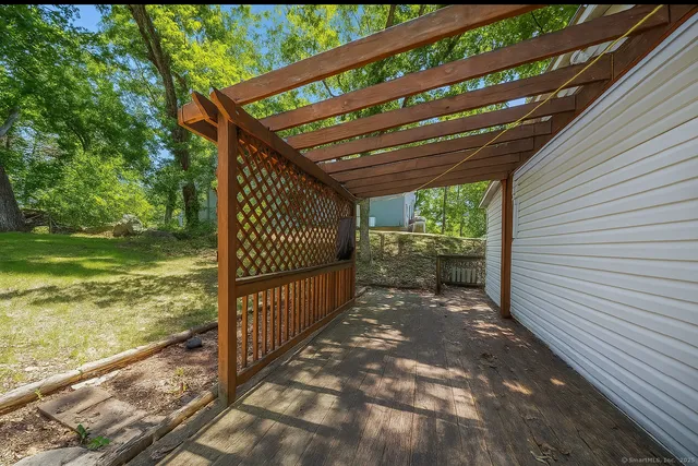 a view of a pathway of a backyard with wooden floor and fence