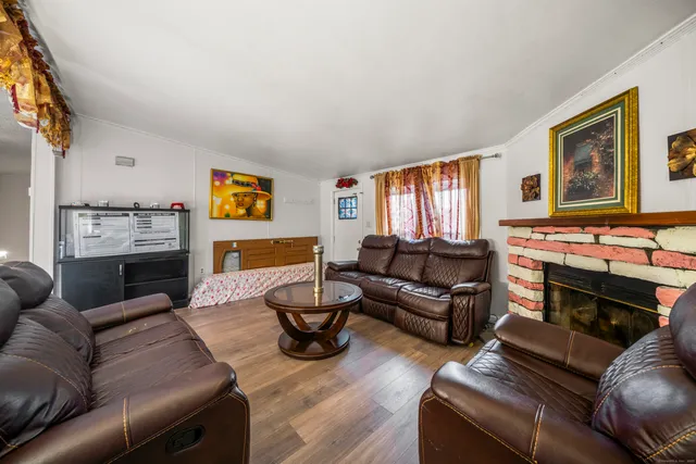 a living room with furniture fireplace and a window