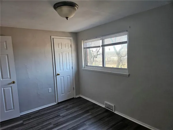 a view of an empty room and wooden floor