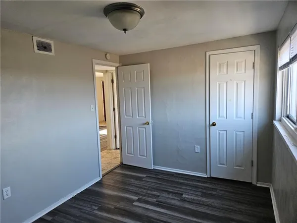 a view of small space with wooden floor and fan