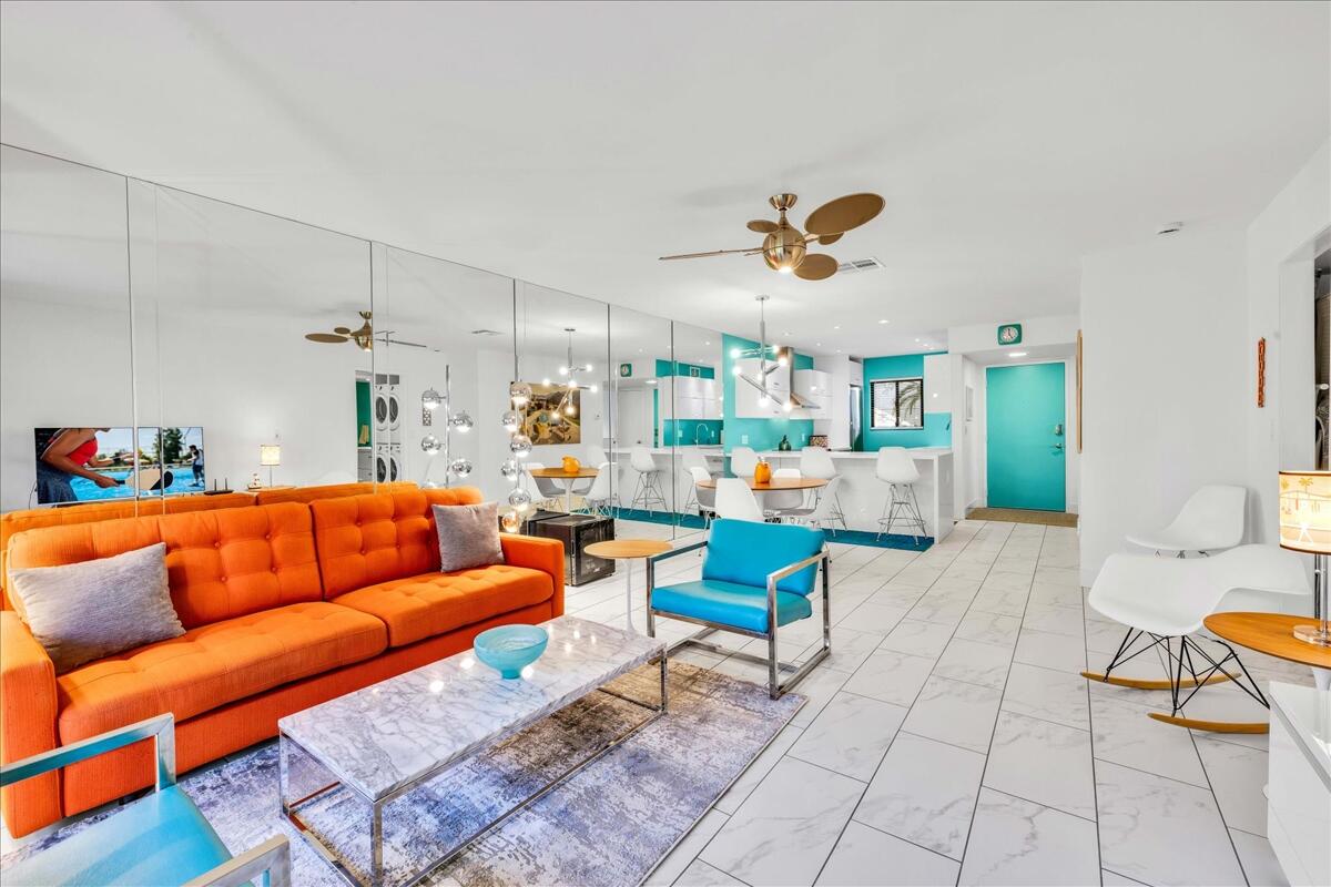 1050 Ramon Road, Unit 110 Palm Springs, CA 92264 - Photo 3 of 28 a living room with furniture a rug and a chandelier