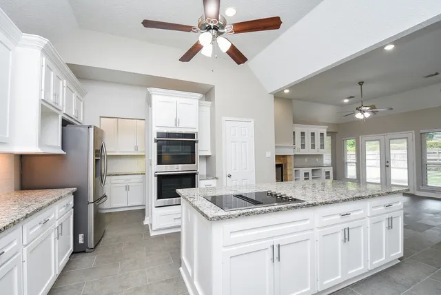 a kitchen with granite countertop a sink stainless steel appliances and cabinets