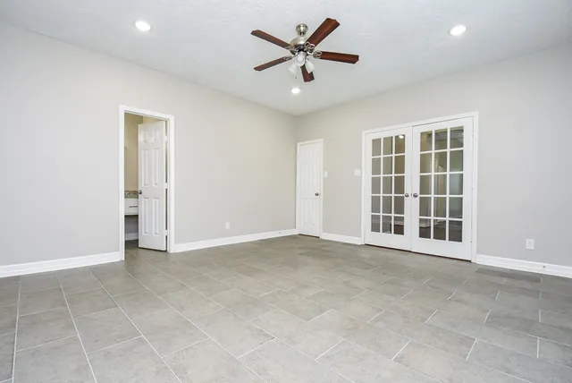 an empty room with a window and a ceiling fan