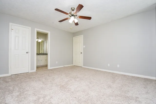 an empty room with closet and fan