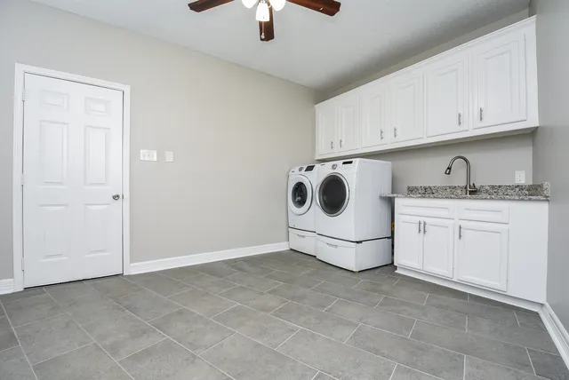 a utility room with cabinets washer and dryer