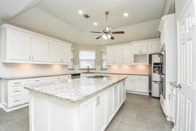 a kitchen with stainless steel appliances granite countertop a sink stove and refrigerator