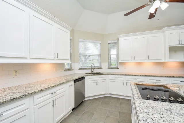 a kitchen with granite countertop sink stainless steel appliances and cabinets