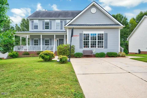a front view of a house with a garden and plants