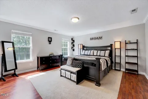 a bedroom with a bed and painting on the wall