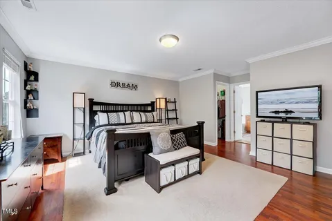 a spacious bedroom with a bed and wooden floor