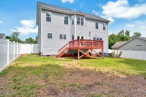 a view of a house with wooden deck and a yard