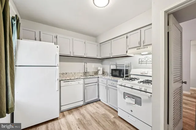 a kitchen with stainless steel appliances a refrigerator sink and white cabinets