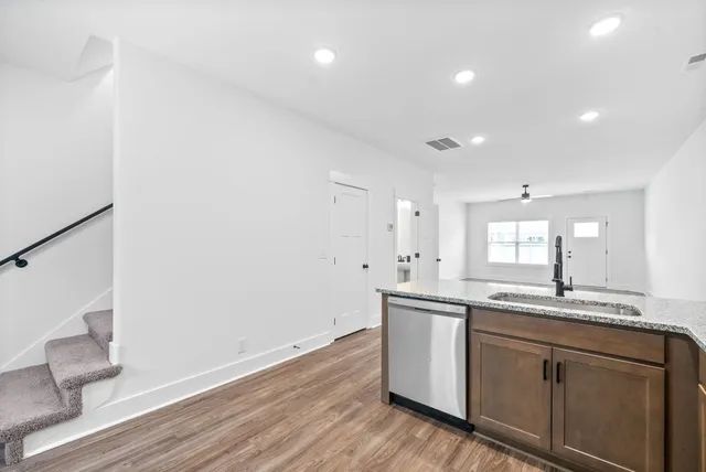 a kitchen with a sink cabinets and wooden floor