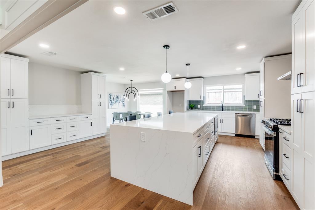 10626 Ferndale Road Dallas, TX 75238 - Photo 1 of 1 Kitchen featuring a center island, appliances with stainless steel finishes, and white cabinetry