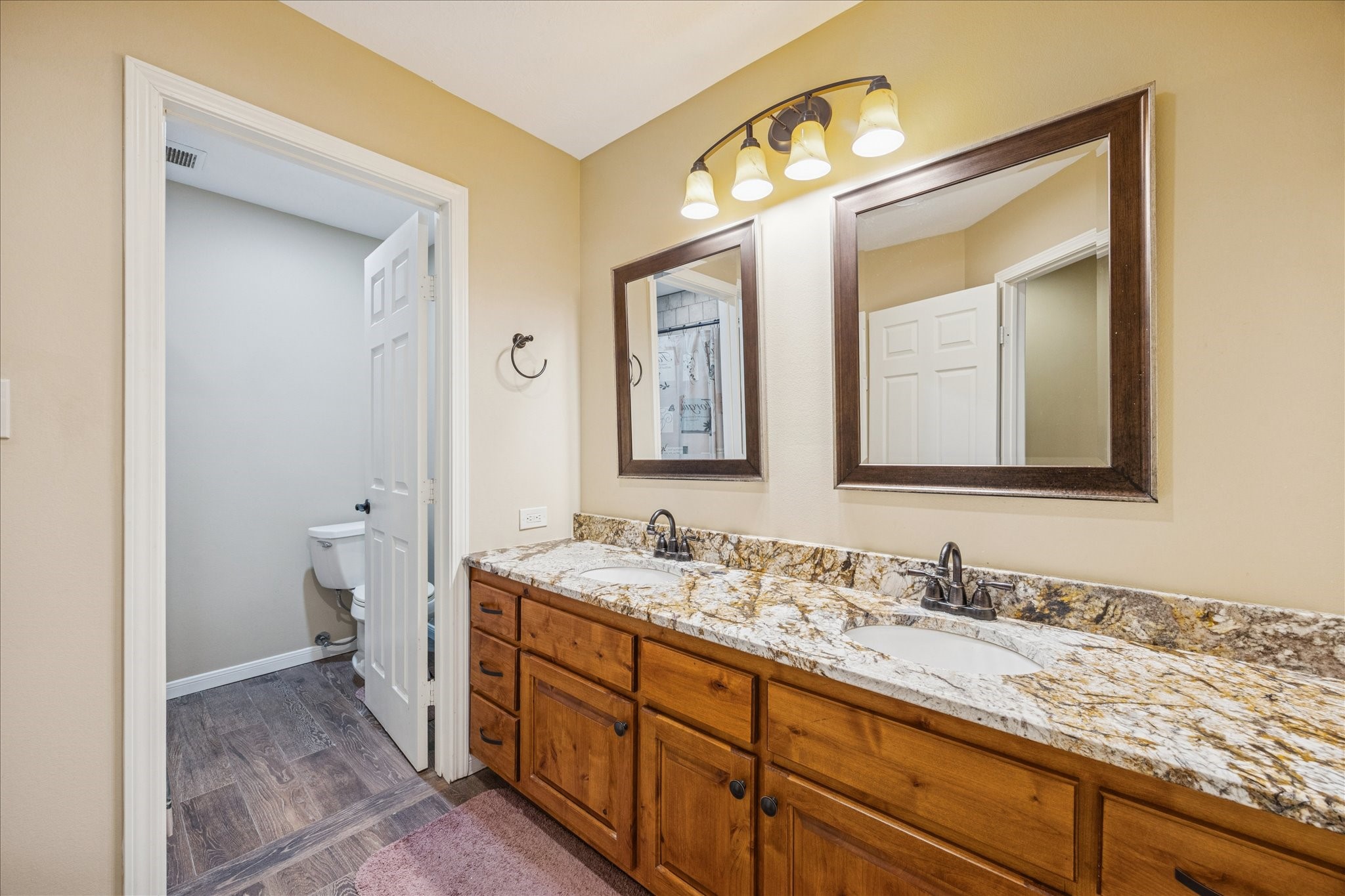 640 Piney Creek Road Bellville, TX 77418 - Photo 20 of 35 a bathroom with a granite countertop double vanity sink and a mirror