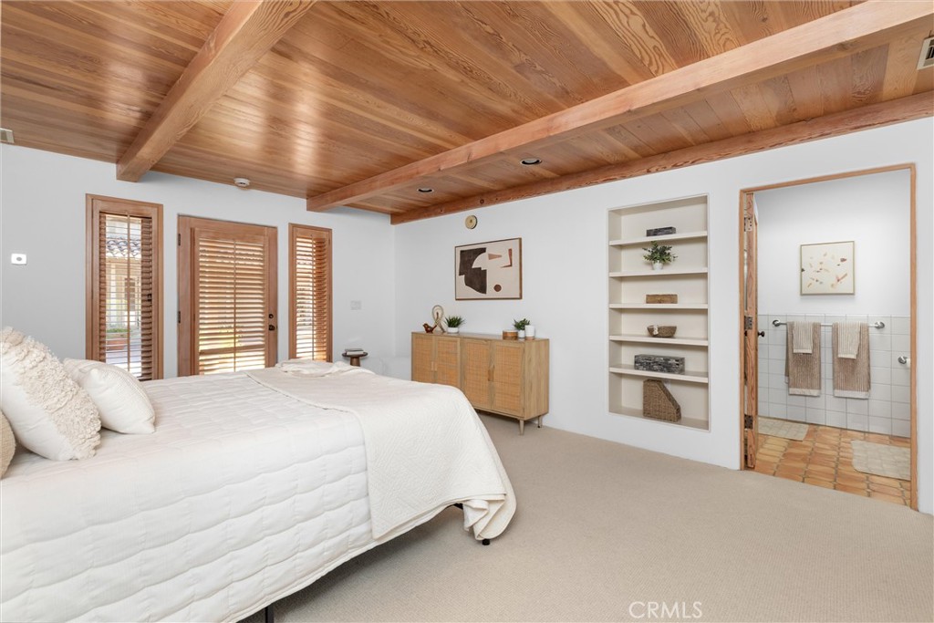 3595 West Oak Trail Road Santa Ynez, CA 93460 - Photo 25 of 60 a spacious bedroom with a large bed and a chandelier
