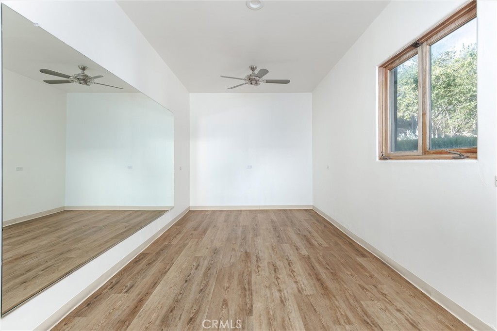 3595 West Oak Trail Road Santa Ynez, CA 93460 - Photo 31 of 60 an empty room with wooden floor cabinet and windows