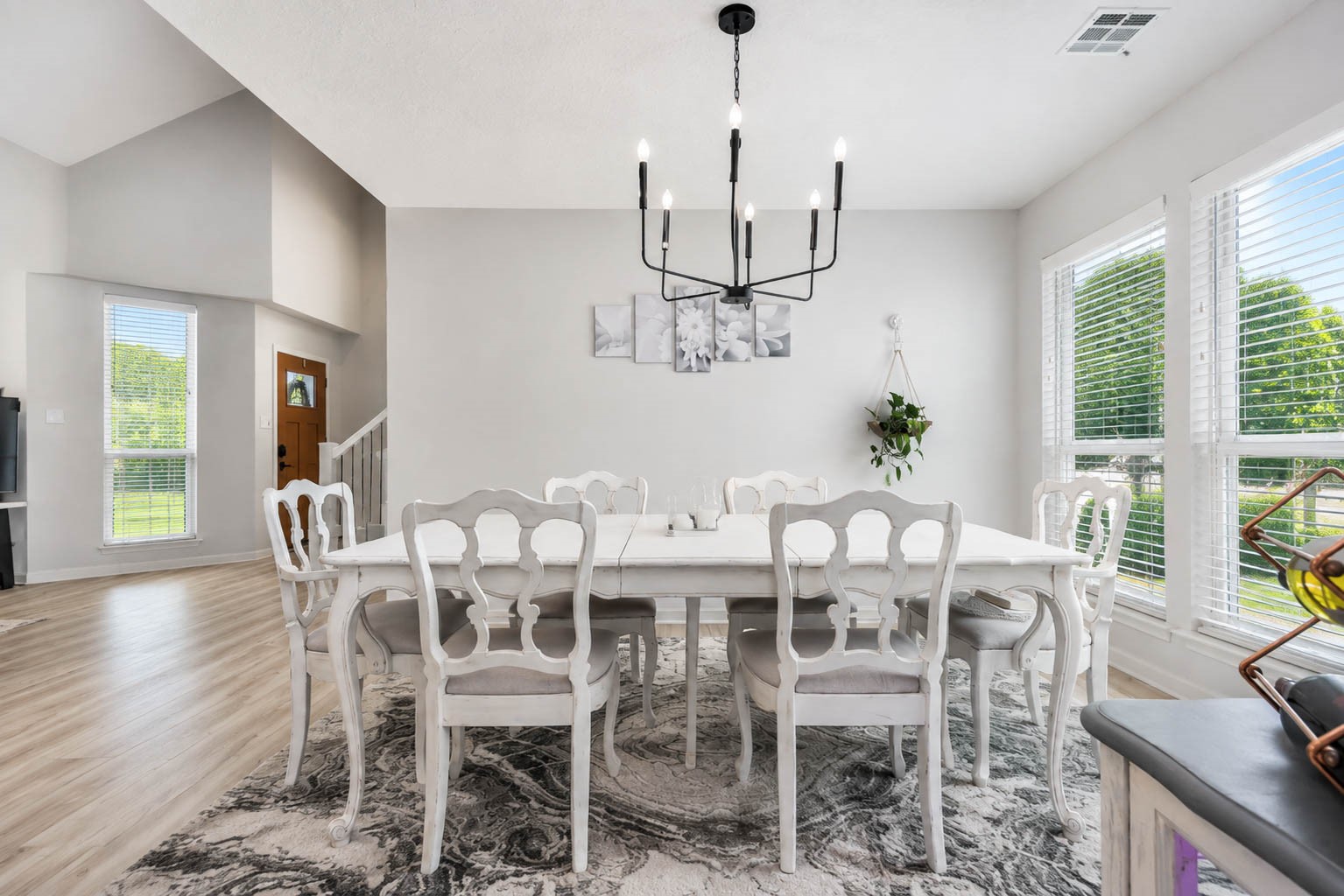 630 South Fry Road Katy, TX 77450 - Photo 12 of 48 Elegant dining room with a long white table, stylish chandelier, and large windows providing abundant natural light.