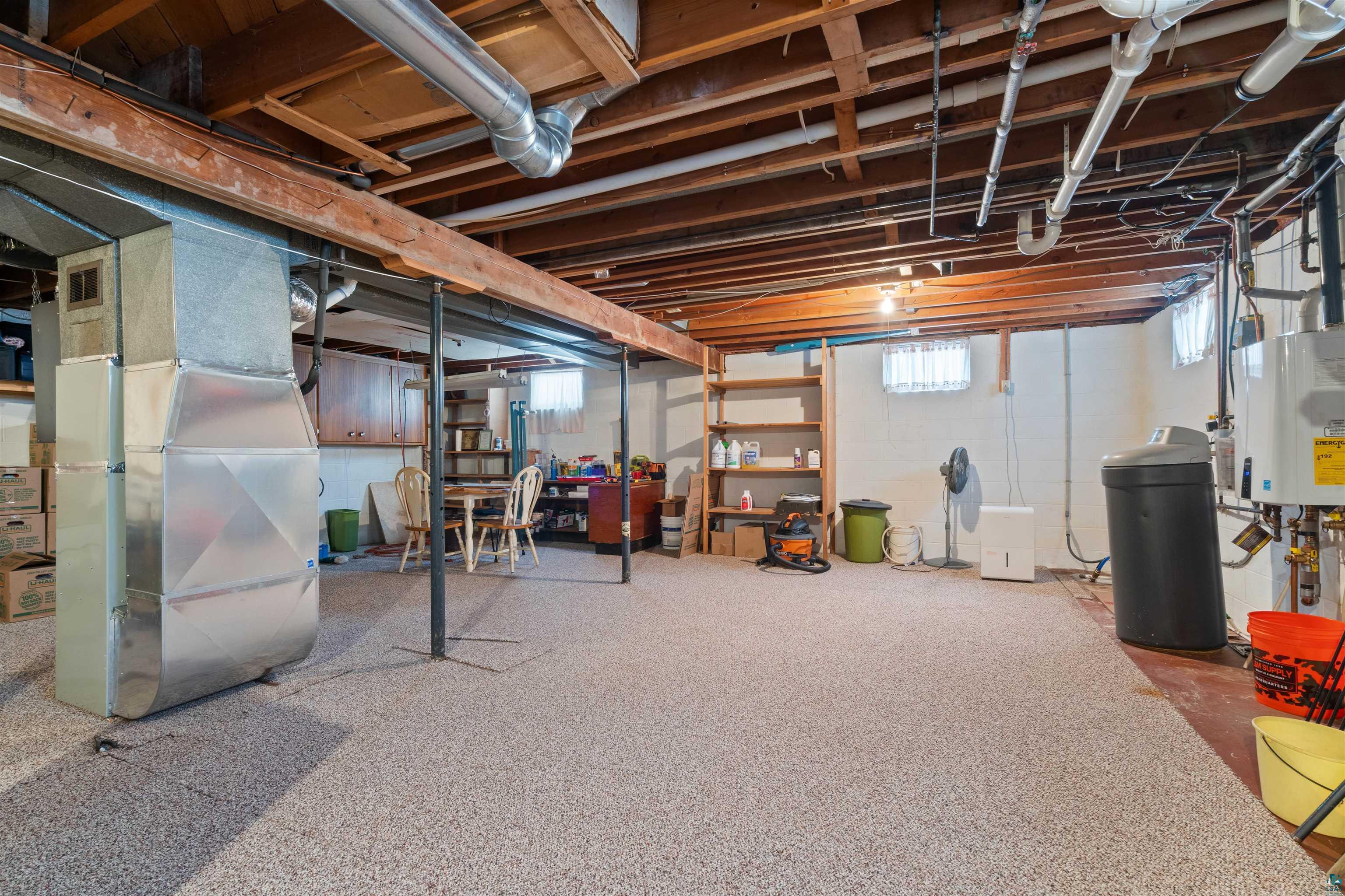 1580 Olsonville Road Carlton, MN 55718 - Photo 15 of 30 Basement featuring a water softener system, heating unit, and tankless water heater