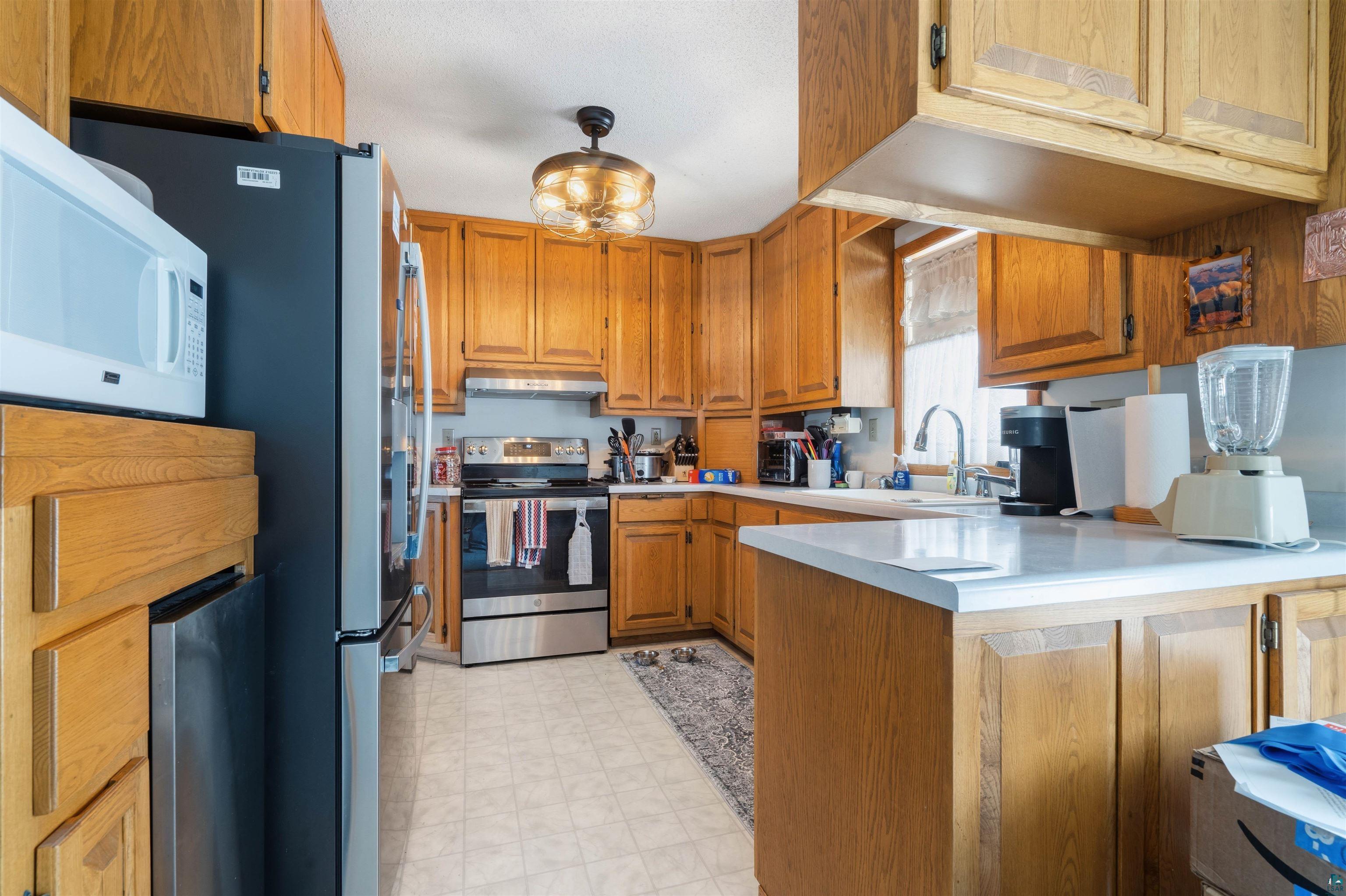1580 Olsonville Road Carlton, MN 55718 - Photo 6 of 30 Kitchen with wood finish cabinets, light floors, light countertops, and stainless steel appliances