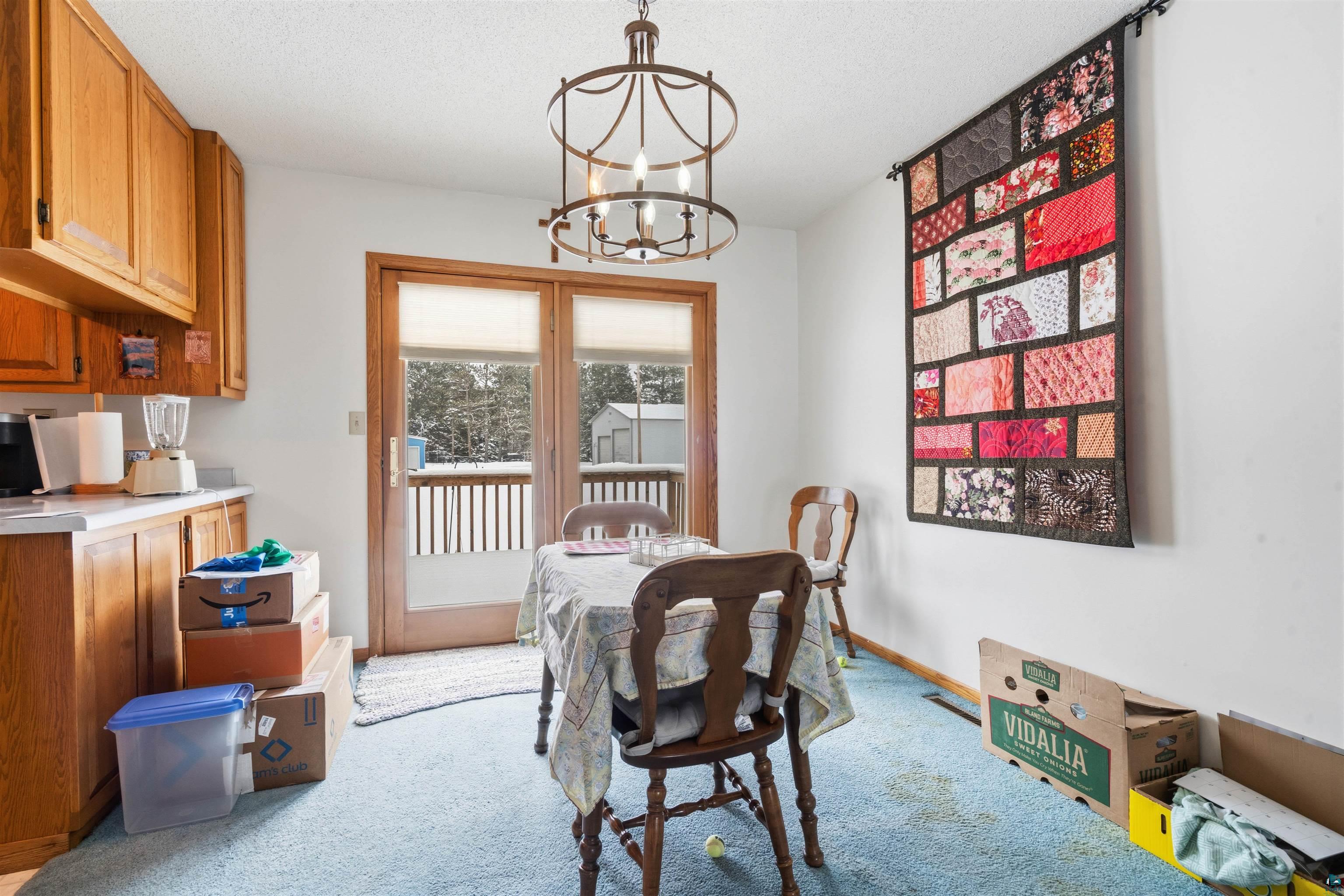 1580 Olsonville Road Carlton, MN 55718 - Photo 9 of 30 Dining space with light colored carpet and a chandelier
