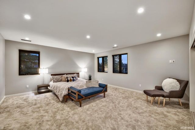 a spacious bedroom with a bed and a lamp