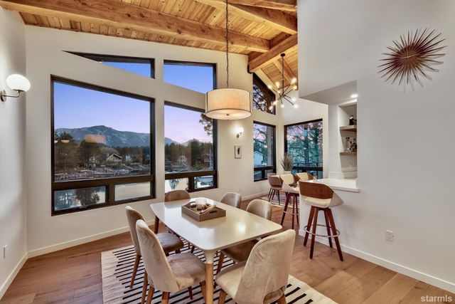 a view of a dining room with furniture large windows and wooden floor