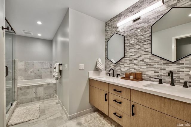 a bathroom with a double vanity sink mirror and shower