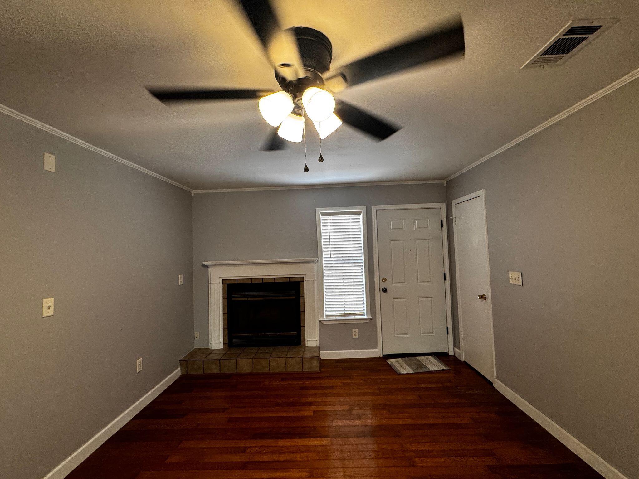 358 John King Road Crestview, FL 32539 - Photo 2 of 22 a view of an empty room with wooden floor fireplace and a window