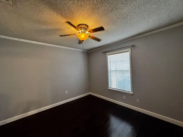an empty room with a window and a ceiling fan