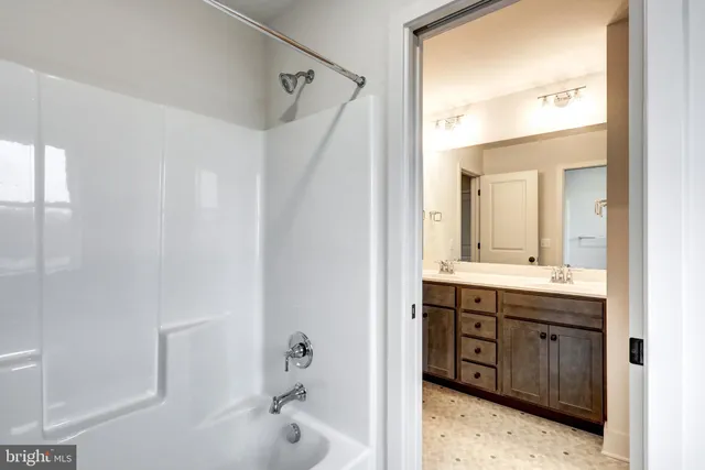 a bathroom with a tub sink and mirror