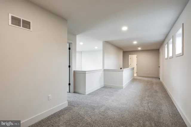 a view of a kitchen with white cabinets and wooden floor