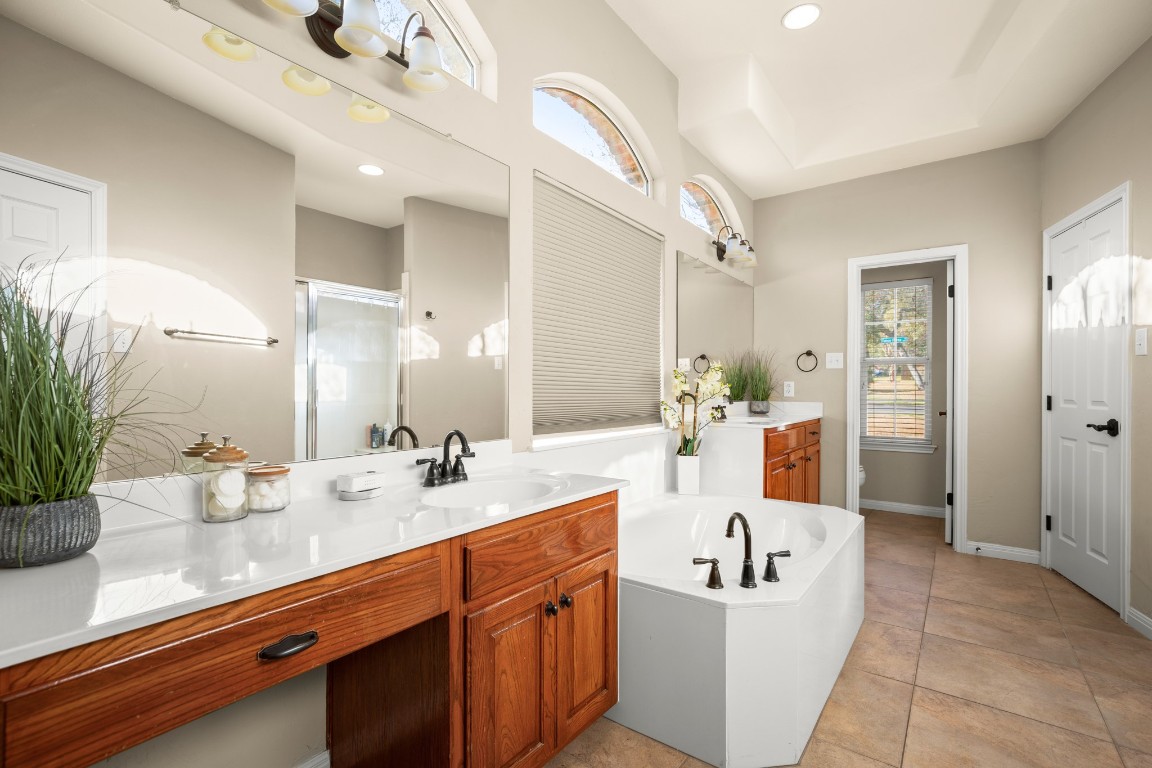 8021 Tahoe Parke Circle Austin, TX 78726 - Photo 21 of 33 a bathroom with a sink double vanity mirror and tub