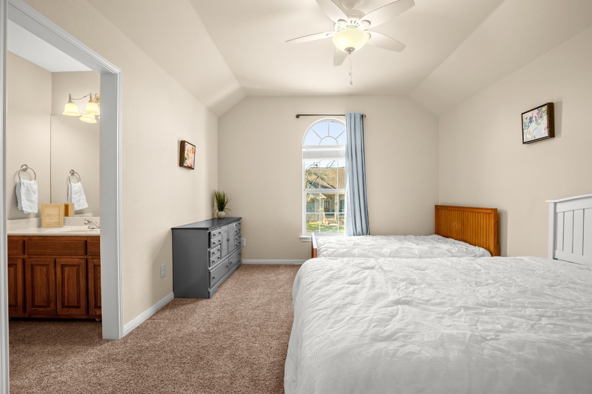 8021 Tahoe Parke Circle Austin, TX 78726 - Photo 25 of 33 a spacious bedroom with a bed and a chandelier