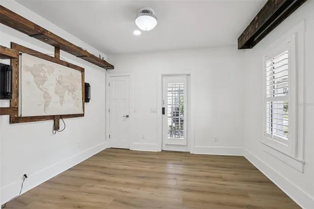 a view of empty room with window and wooden floor