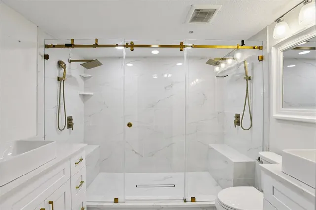 a bathroom with a sink a toilet and shower