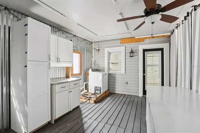 a room with white cabinets and wooden floor