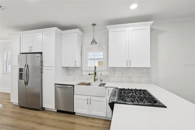 a kitchen with white cabinets and stainless steel appliances
