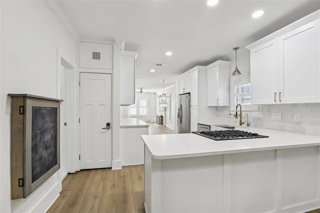 a kitchen with stainless steel appliances granite countertop a sink stove and cabinets