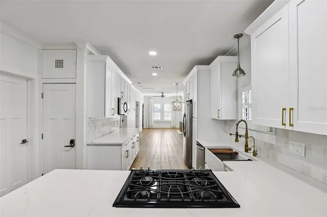 a kitchen with stainless steel appliances a stove a sink and a refrigerator