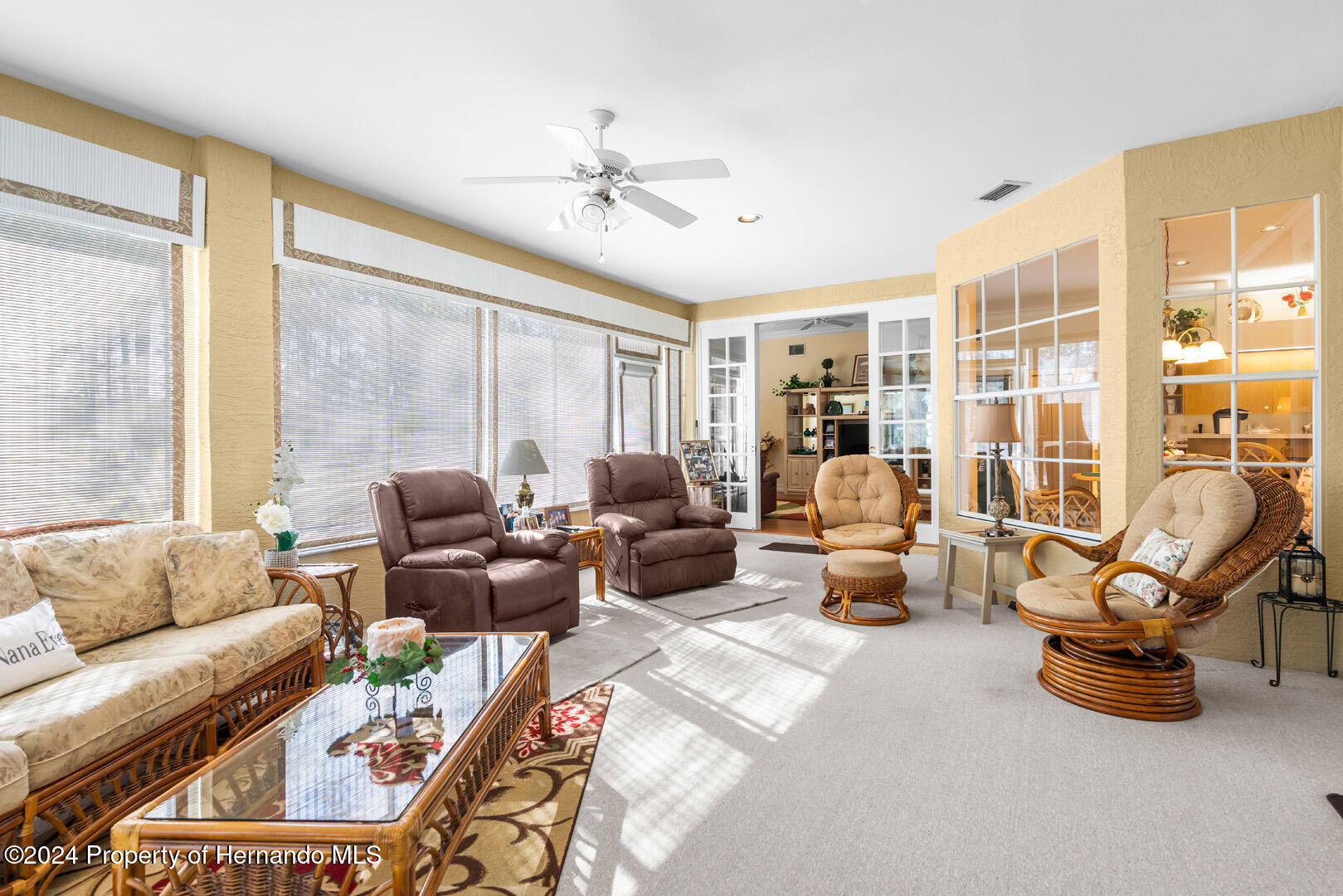 7424 Harvard Hills Place Spring Hill, FL 34606 - Photo 15 of 38 a living room with furniture and floor to ceiling windows