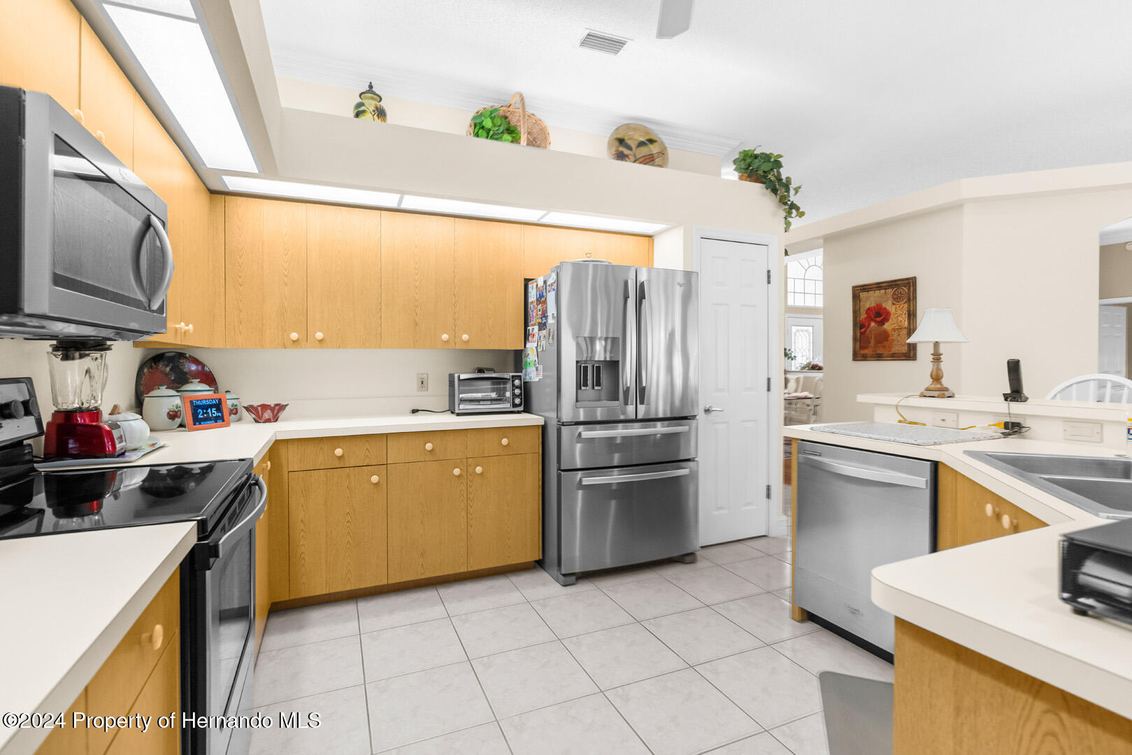 7424 Harvard Hills Place Spring Hill, FL 34606 - Photo 20 of 38 a kitchen with a sink cabinets and stainless steel appliances