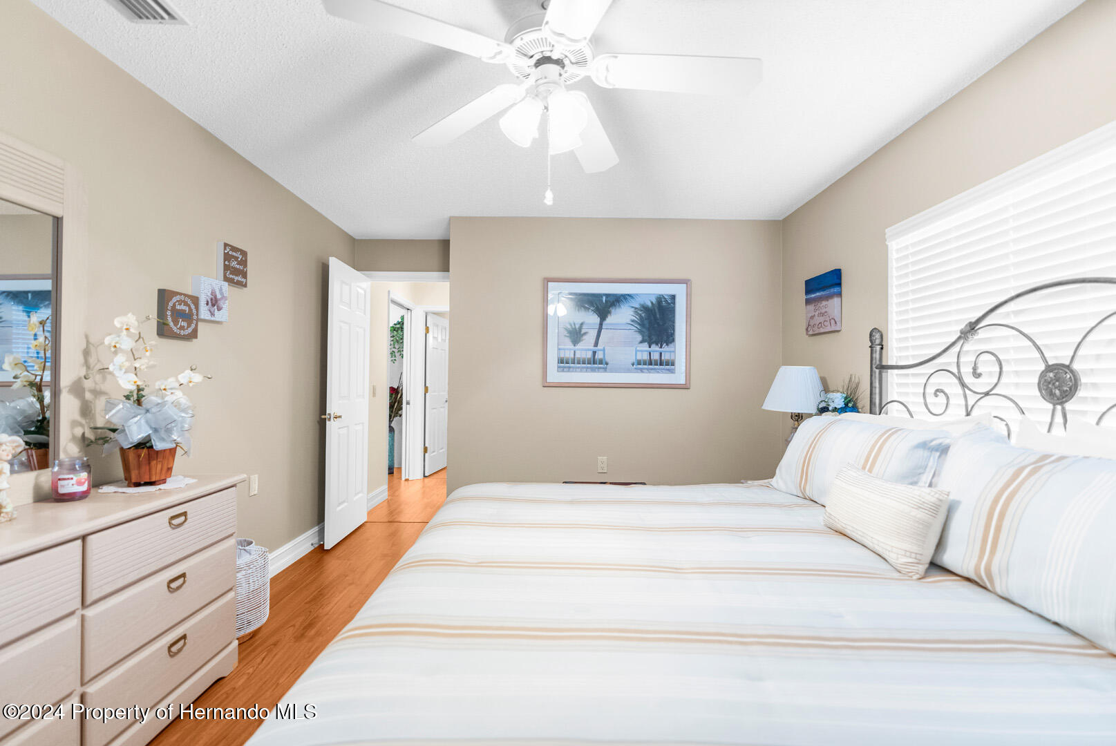 7424 Harvard Hills Place Spring Hill, FL 34606 - Photo 32 of 38 a bedroom with a large bed and a chandelier