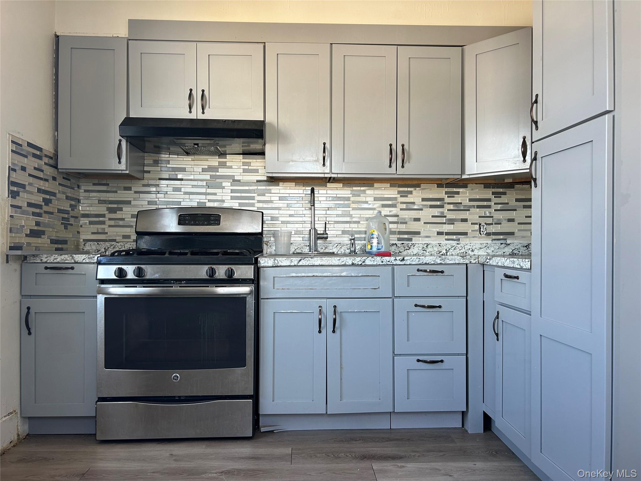 139 Derby Street Valley Stream, NY 11581 - Photo 11 of 14 a kitchen with stainless steel appliances white cabinets granite counter tops and a stove