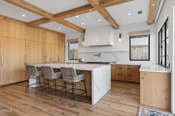 a kitchen with stainless steel appliances granite countertop a table chairs sink and cabinets