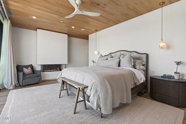 a bedroom with a large bed and a flat tv screen on dresser